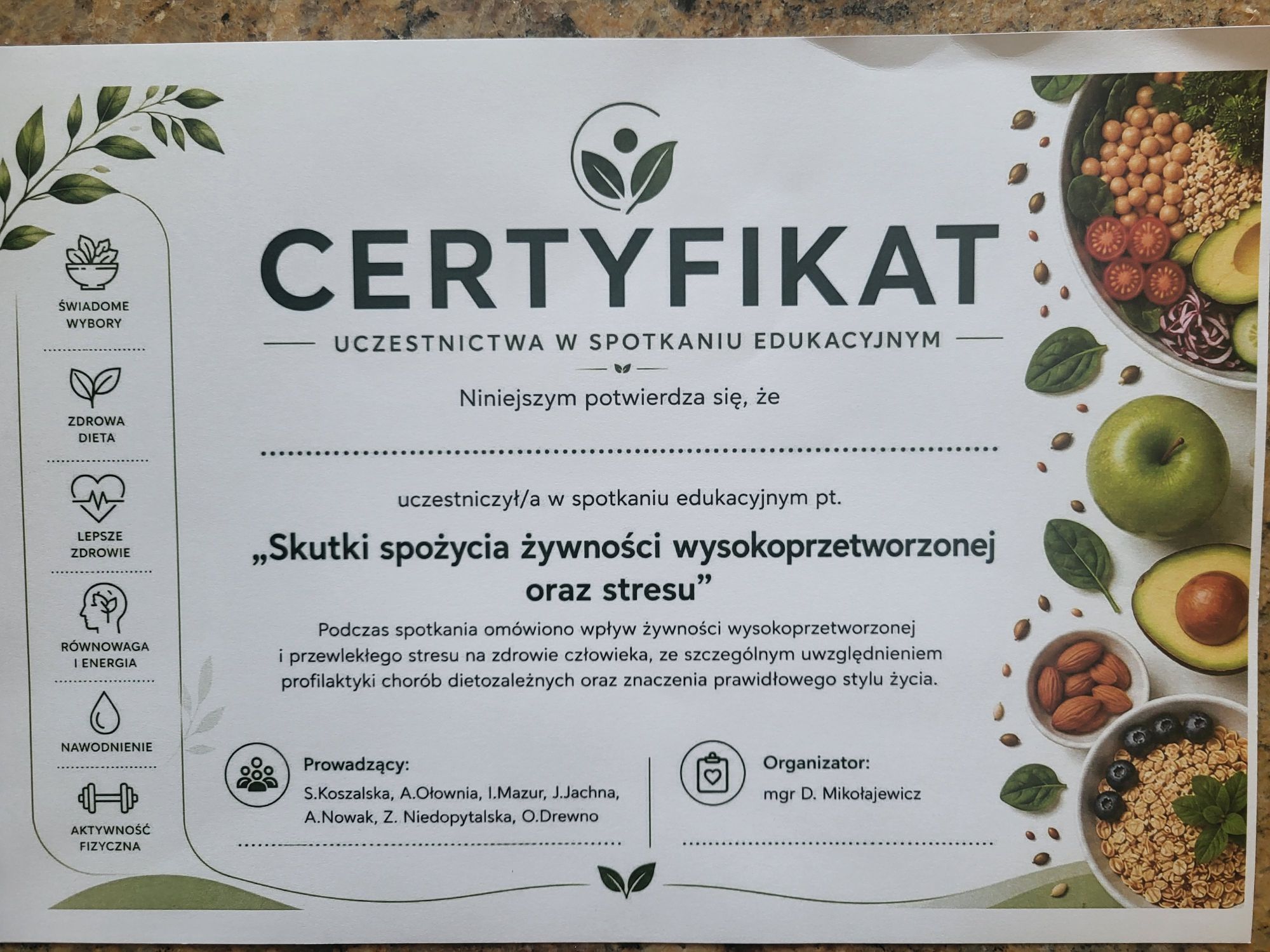 Certyfikat potwierdzający udział w spotkaniu edukacyjnym poświęconym zdrowemu stylowi życia i prawidłowemu żywieniu. Dokument utrzymany jest w zielonej kolorystyce i ozdobiony grafikami przedstawiającymi zdrową żywność oraz symbole związane z profilaktyką zdrowotną. W treści znajdują się informacje o organizatorach, prowadzących oraz celu wydarzenia.