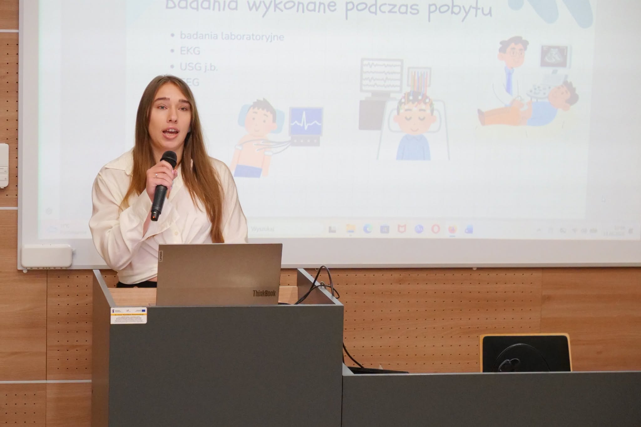 Prelegentka prowadzi wystąpienie podczas wydarzenia o charakterze edukacyjnym, prezentując zagadnienia związane z ochroną zdrowia. Wykład stanowi element szkolenia, konferencji lub spotkania naukowego. Wydarzenie sprzyja zdobywaniu wiedzy oraz wymianie doświadczeń między uczestnikami.