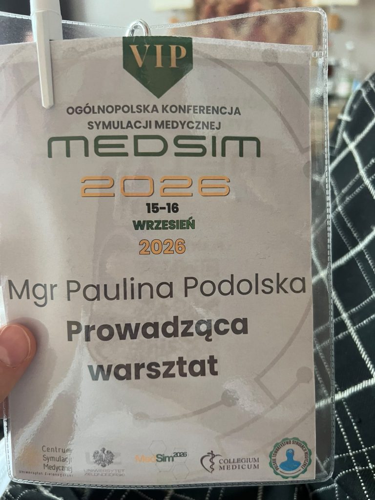 Zbliżenie na identyfikator konferencyjny w przezroczystej koszulce. Na identyfikatorze widnieje napis: &bdquo;VIP&rdquo;, &bdquo;Og&oacute;lnopolska Konferencja Symulacji Medycznej MEDSIM 2026&rdquo;, termin &bdquo;15-16 wrzesień 2026&rdquo; oraz informacja &bdquo;Prowadząca warsztat&rdquo;. W dolnej części znajdują się logotypy organizator&oacute;w i partner&oacute;w wydarzenia.